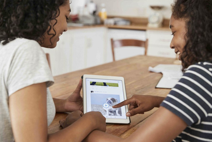 An image of foster siblings playing on an ipad