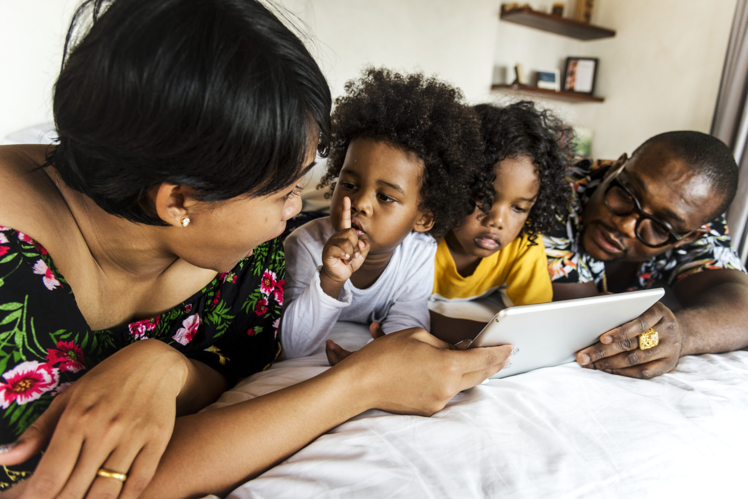 African family on bed using a tablet